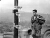 Film still of Charlie Sheen wearing a military uniform walking past sign posts Photo Print - Item # VARCEL684983
