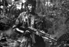 Film still of Charlie Sheen wearing a military uniform and carrying a gun Photo Print - Item # VARCEL684984