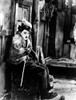 A film still of Charlie Chaplin sitting outdoors Photo Print - Item # VARCEL688066