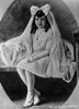 Claudette Colbert sitting on Bed, wearing White Dress with Veil Photo Print - Item # VARCEL688495