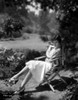 Claudette Colbert sitting on Chair, wearing White Dress Photo Print - Item # VARCEL688498