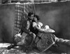 Bebe Daniels Leaning Back on the Man's Chest while Holding a White Sombrero in White Blouse and Floral Skirt Photo Print - Item # VARCEL696696