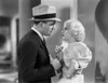 Jean Harlow Scene from a Film standing In front of a Man in White Tartan Mutton Short Sleeve Dress with Hands Together and Fingers Crossed Photo Print - Item # VARCEL697097