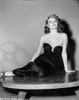 Rita Hayworth Seated on Table in a Black Gown Photo Print - Item # VARCEL698150