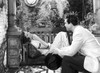 Katharine Hepburn Lying on Bench with A Man Talking in Black and White Photo Print - Item # VARCEL699176