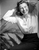 Anne Baxter posed on Floral Dress sitting and smiling Photo Print - Item # VARCEL699850