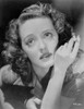 Bette Davis Close Up Portrait Looking Up in Black Suit Dress while Holding a Cigarette Photo Print - Item # VARCEL692937