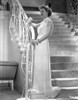 Bette Davis Posed Holding on the Staircase Railing in White Sleeveless Chiffon Long Dress Photo Print - Item # VARCEL692992