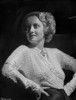 Bette Davis Posed Hands on the Waist and Looking to the Right in Glossy Long Sleeve High Neck Dress and Black Skirt Photo Print - Item # VARCEL693025