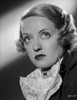 Bette Davis Portrait Looking Up with Curled Hair in White Linen scarf Strapped with Brooch and Black Dress Photo Print - Item # VARCEL693090