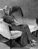 Bette Davis Seated on a White Couch with Arms on the Chair Arm and Hand on the Lap in Black Polka Dot Dress Photo Print - Item # VARCEL693118