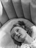 Bette Davis Lying on the Couch in White Dress Photo Print - Item # VARCEL693223