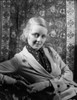 Bette Davis Leaning Back on the Chair in Black Polka Dot Neckerchief and White Suit Dress Photo Print - Item # VARCEL693420