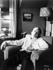 James Dean Seated and Leaning Back on a Couch in White Long Sleeve Collar Shirt and Black Linen Pants Photo Print - Item # VARCEL694053