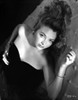 Jean Brooks on the Bed in Black Strapless Dress and Bracelet with Right Hand on the Chest Photo Print - Item # VARCEL695042