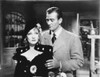 Marlene Dietrich standing in Black Dress with Man, wearing Checkered Suit Photo Print - Item # VARCEL695474