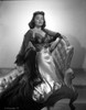 Donna Reed on a Dress Kneeling on Couch in Black and White Photo Print - Item # VARCEL703566