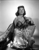 Donna Reed on a Dress Kneeling on Couch Photo Print - Item # VARCEL703568