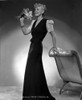 Penny Singleton standing and Holding Flowers in Black Elegant Dress Photo Print - Item # VARCEL704591