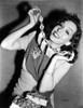 Lupe Velez smiling in Elegant Dress while Putting on Her Necklace Photo Print - Item # VARCEL705349