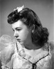 Jane Withers Portrait in Ruffled Lace Neckline and Sheer Silk Short Sleeve Blouse with White Flower Headband while the Head Turn to the Right Photo Print - Item # VARCEL705597