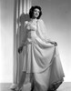 Jane Withers Posed in White Silk Keyhole-Neck Long Sleeve Dress with Left Hand Holding Skirt Up Photo Print - Item # VARCEL705607