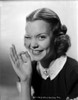 Jane Wyman Portrait in White Collar and Black Velvet Short Sleeve Dress with Right Eye Winked and Right Hand in OK Hand Gesture Photo Print - Item # VARCEL705821