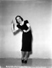 Jane Wyman Posed in Black Velvet Short Sleeve Dress with White Ruffle Collar and Sleeves while Hands Raised Up and Feet Together Photo Print - Item # VARCEL705858