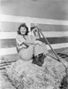 Barbara Stanwyck sitting in Hay Stack Classic Portrait Photo Print - Item # VARCEL707595