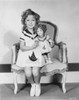 Shirley Temple sitting on Chair with a Doll in White Dress Photo Print - Item # VARCEL708430