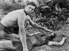 Johnny Weissmuller Checking a Woman's Temperature Who's Lying on the Ground in a Classic Movie Scene Photo Print - Item # VARCEL709361