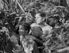 Johnny Weissmuller Hiding in the Bush with His Friend in a Movie Scene Photo Print - Item # VARCEL709348