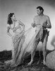 Johnny Weissmuller Holding a Fish Net with a Woman in a Classic Movie Scene Photo Print - Item # VARCEL709398