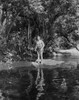 Johnny Weissmuller standing on a Rock in the River in a Classic Movie Scene Photo Print - Item # VARCEL709411
