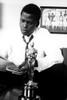 Sidney Poitier reading a newspaper with an Oscars statuette Photo Print - Item # VARGLP347019