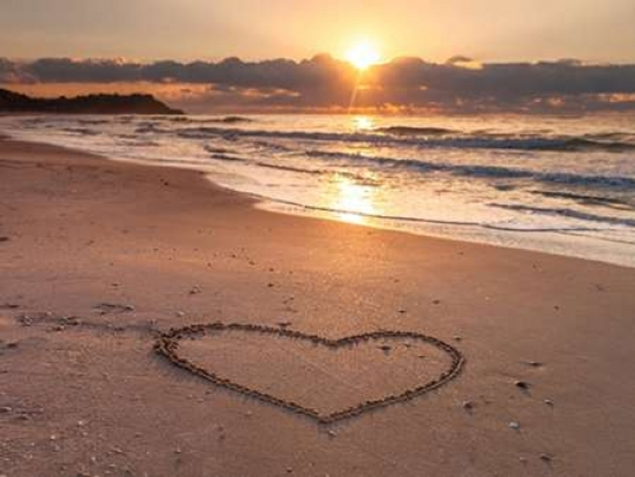 hearts in the sand at sunset