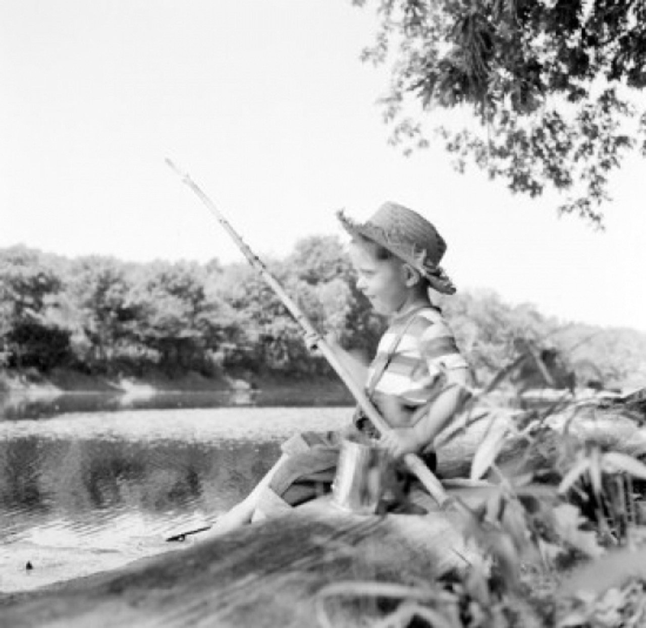 Boy sitting on riverbank and fishing Poster Print - Item # VARSAL255424547