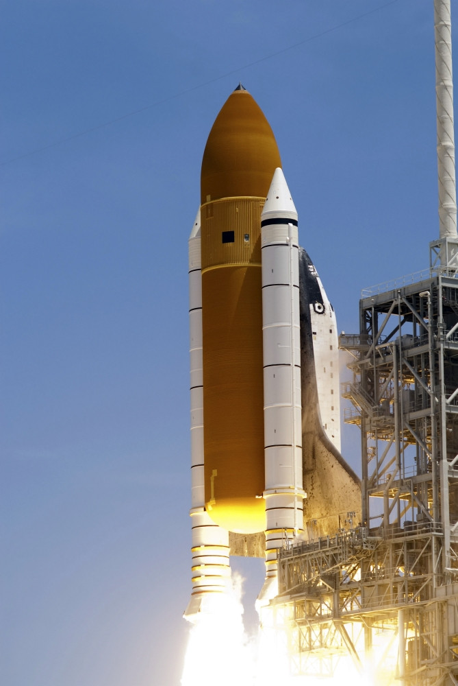 Space shuttle Atlantis' twin solid rocket boosters ignite to