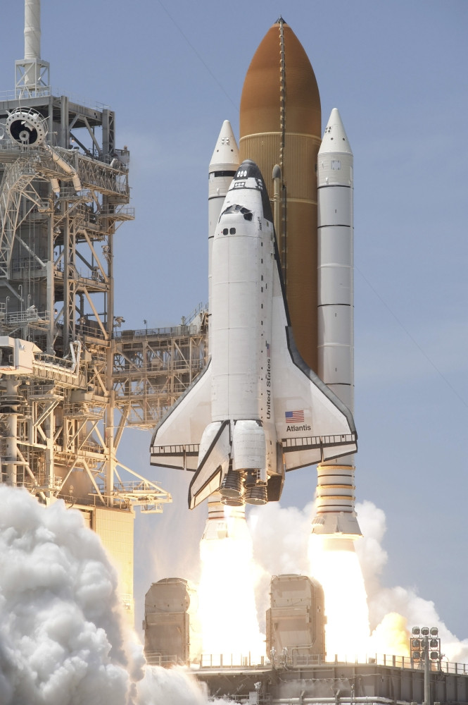 Space shuttle Atlantis' twin solid rocket boosters ignite to