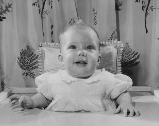 Baby girl sitting in a high chair Poster Print Item VARSAL2559688F