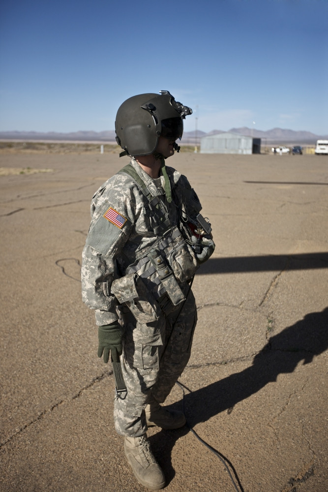 Crew chief of a CH-47 Chinook stands outside the aircraft during