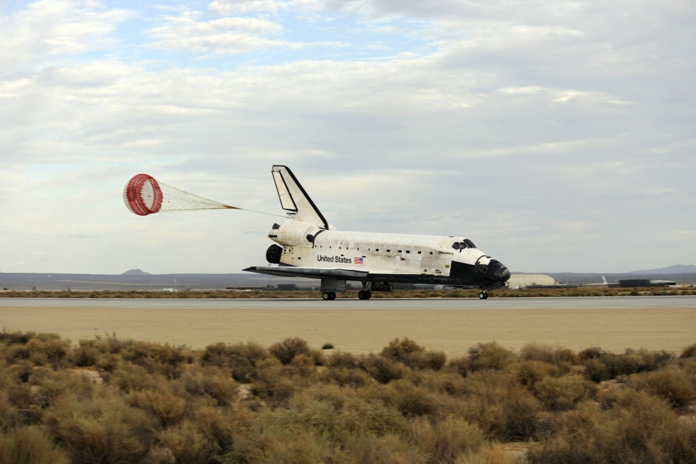 Space Shuttle Discovery deploys its drag chute as the vehicle comes to ...