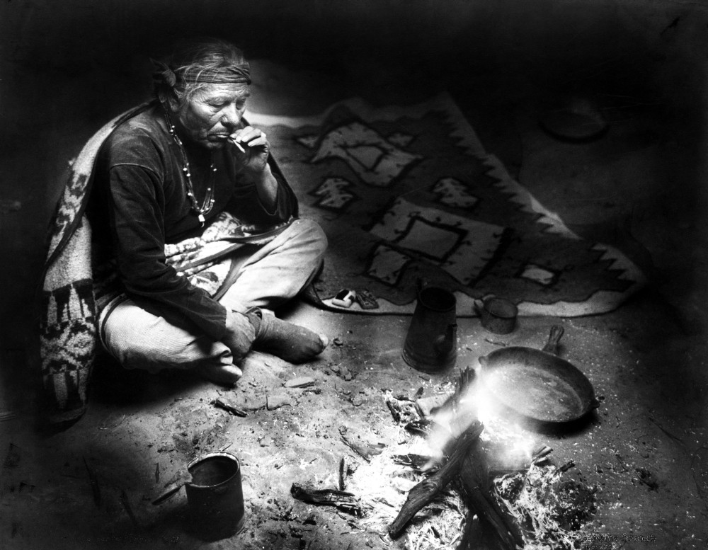 Navajo Man Smoking, C1915. /Na Navajo Man Seated Near A Fire, Smoking A Cigarette  After A Meal. Photograph By William Carpenter, C1915. Poster Print by  Granger Collection - Item # VARGRC0116634