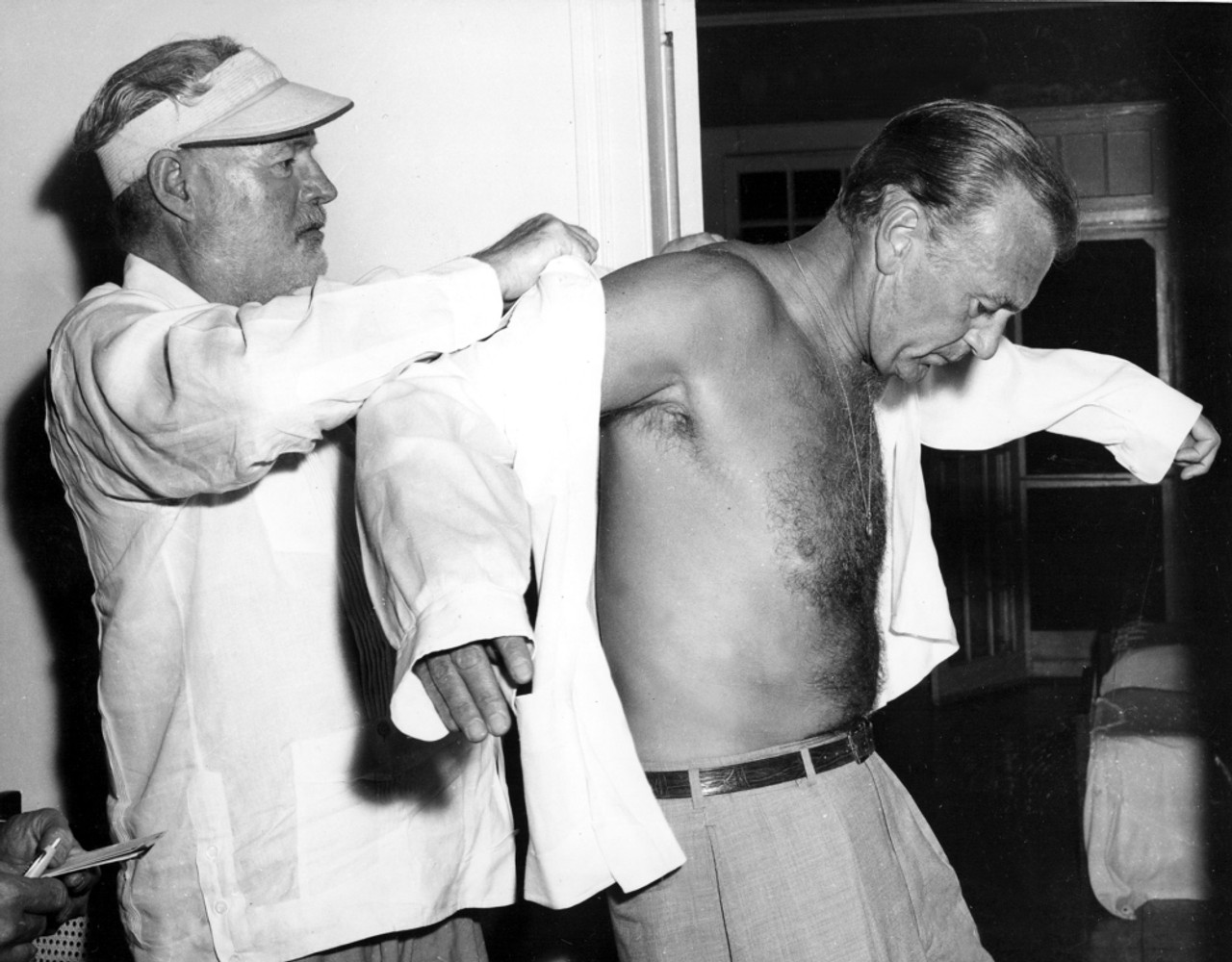 Ernest Hemingway Helps Buddy Gary Cooper Into A More Comfortable Guayabera Shirt Upon The Actor'S Arrival In Cuba History - Item # VAREVCPBDGACOEC081 - Posterazzi