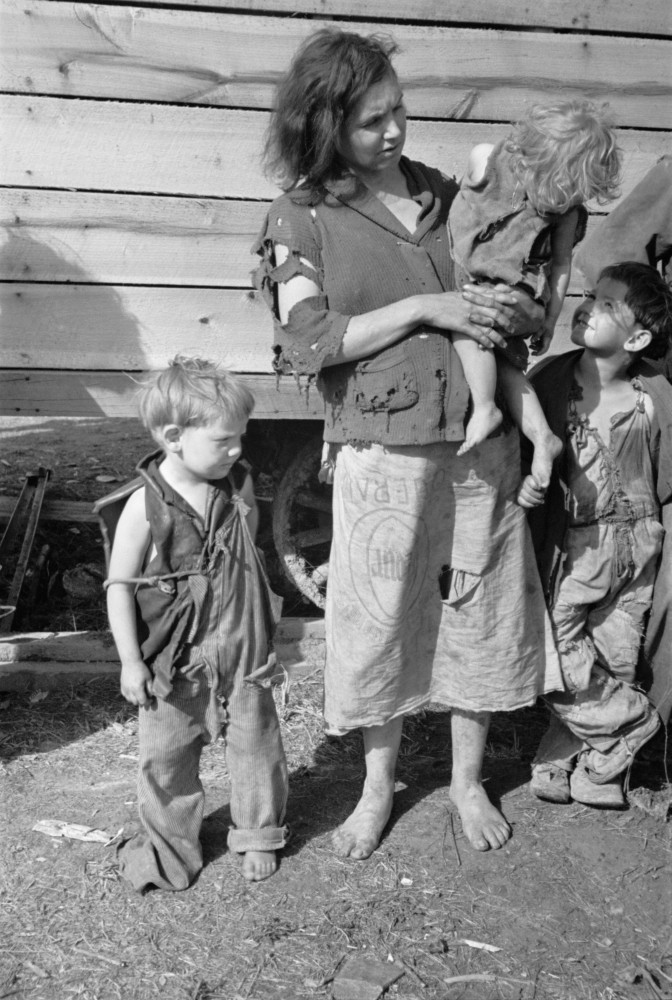 Young Mother Dressed In A Ragged Sweater And A Skirt Made Of A