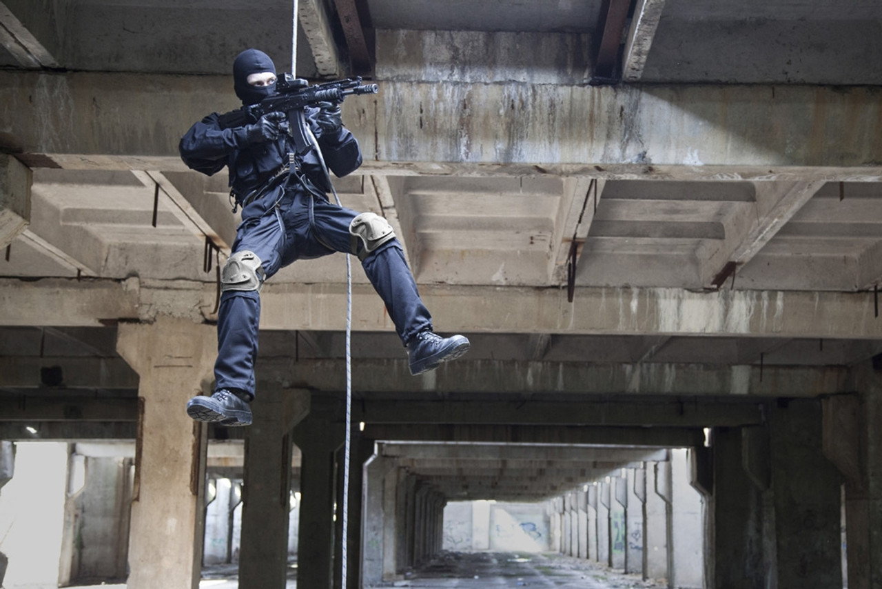 Special forces operator during assault rappelling with weapons