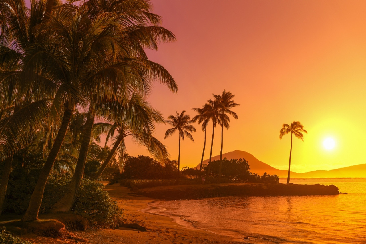 Sunrise at Kahala Beach, Wai_alae Beach Park, with a glowing yellow sun and  warm coloured lights reflected in the tranquil water; Oahu, Hawaii, United  