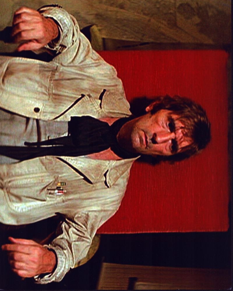 Harry Dean Stanton Sitting In Chair In In Escape From New York