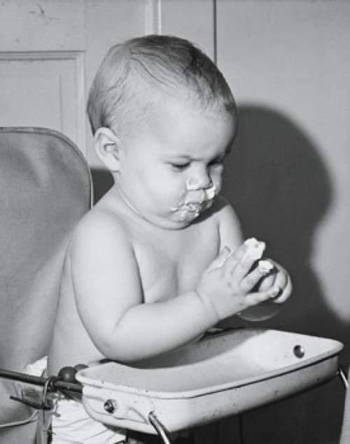 Baby sitting in a high chair and eating food Poster Print - Item # VARSAL2559690