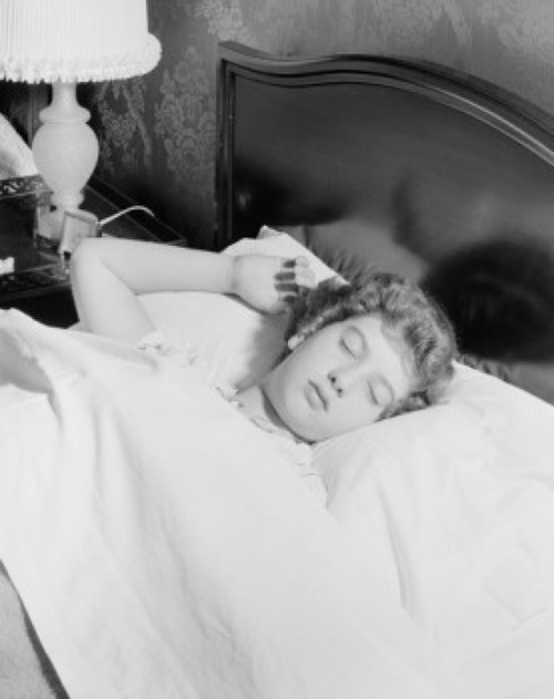 Young woman sleeping in bed Poster Print